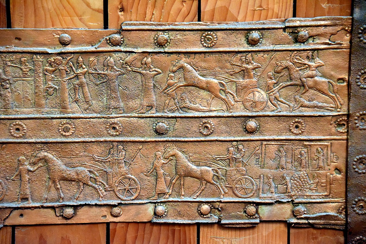 1280px-Detail_of_a_stripe_of_Balawat_gate,_from_Tell_Balawat,_the_British_Museum.jpg